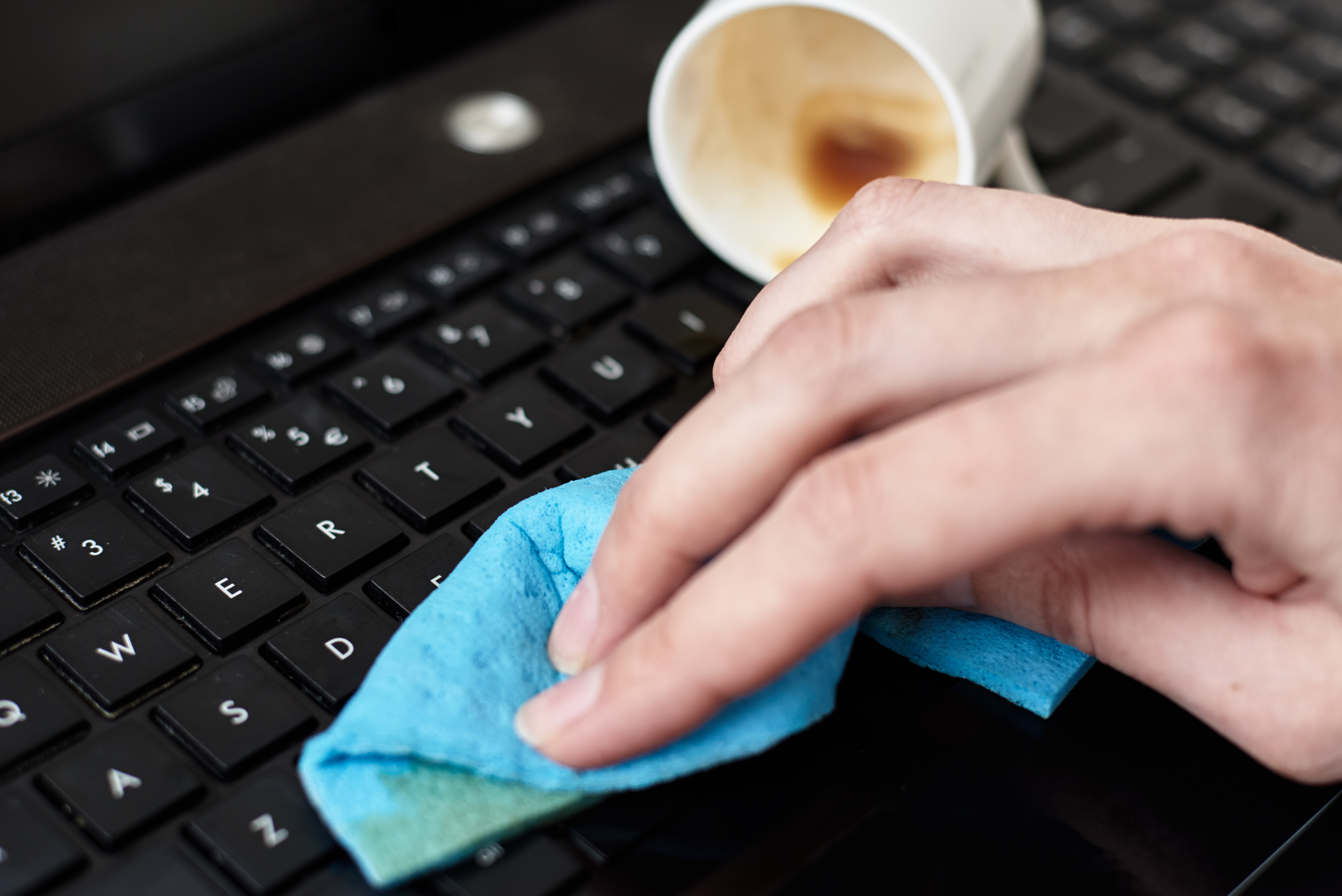 hand-cleans-spilled-coffee-on-laptop-keyboard-with-2023-11-27-04-49-24-utc.jpg